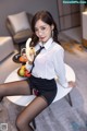 a woman sitting on top of a white table holding a banana