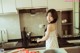 A woman standing in a kitchen preparing food.