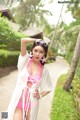 A woman in a pink bikini posing for a picture.