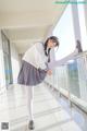 A woman in a school uniform is posing for a picture.