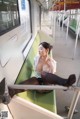 A woman sitting on a subway train with her legs crossed.