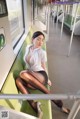 A woman sitting on a green bench on a train.