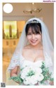 A woman in a wedding dress holding a bouquet of flowers.