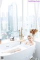 A woman sitting in a bathtub with a plate of food.