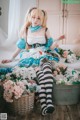 A woman sitting on top of a bed next to a basket of flowers.