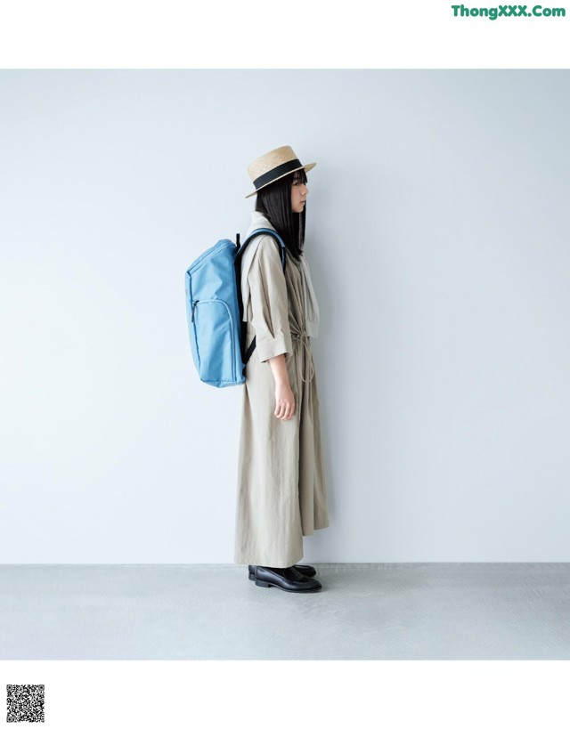 A woman wearing a hat and a blue backpack.