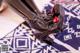 A close up of a pair of black boots on a blue and white rug.