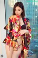 A woman in a black bikini and a colorful kimono.