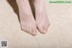 A close up of a woman's feet on a tiled floor.