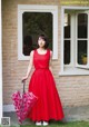 A woman in a red dress holding an umbrella.