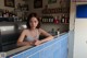 A woman sitting at a counter in a restaurant.