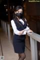 A woman wearing a face mask standing on a balcony.