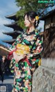 A woman in a kimono standing in front of a building.