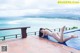 A woman in a white bikini laying on the edge of a swimming pool.