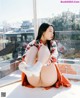 A woman sitting on a window sill with her legs crossed.