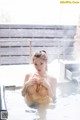 A woman in a yellow bikini sitting in a hot tub.