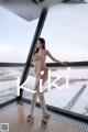 A naked woman standing in front of a window in the snow.