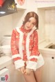 A woman in a red and white outfit posing in a kitchen.