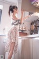 A woman standing in a kitchen next to a stove.