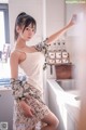 A woman standing in a kitchen next to a sink.