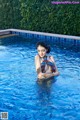 A woman in a bikini standing in a swimming pool.