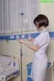 A woman in a hospital room holding a bottle of water.