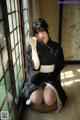 A woman in a black and white kimono sitting on a window sill.