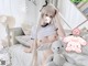 A woman sitting on a bed with a stuffed animal.